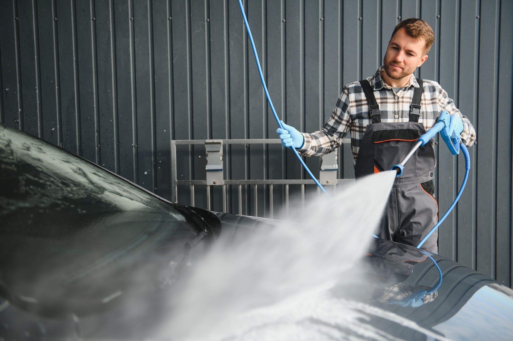 Spécialiste du lavage auto utilisant un nettoyeur haute pression pour rincer une voiture. confier à CleanCarByKev